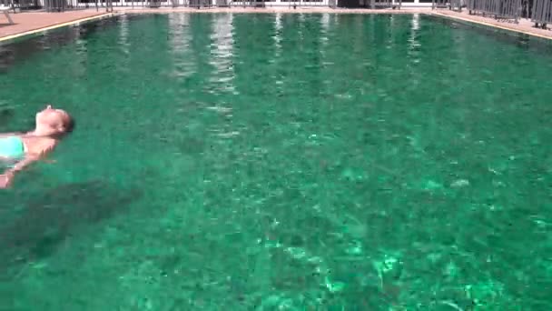 Frau schwimmt im Freibad rückwärts — Stockvideo
