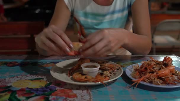 Mujer comiendo camarones con las manos en un café de la calle — Vídeos de Stock