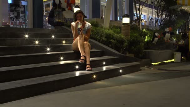 Una donna è seduta sui gradini di un centro commerciale e beve Bubble Tea — Video Stock