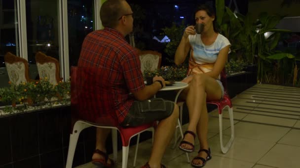 Hombre mujer sentado a la mesa en el vestíbulo del hotel y beber café con galletas — Vídeos de Stock