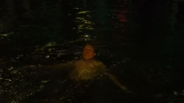 Ein Mann schwimmt abends im Pool — Stockvideo