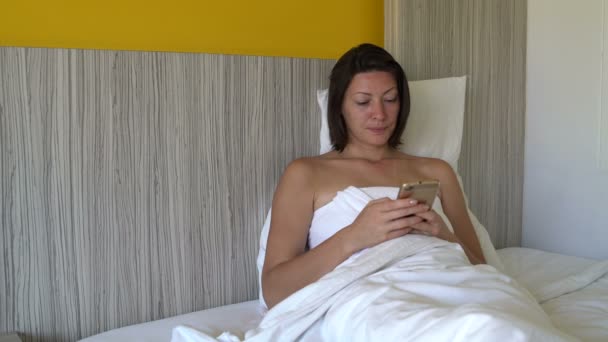 Eine Frau liegt im Bett und riecht das Geld — Stockvideo