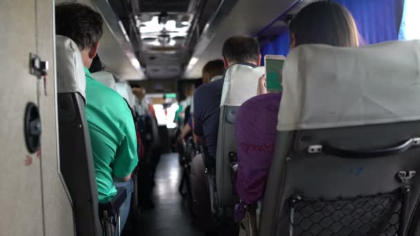Människor reser i bussen. En kvinna studerar en karta på en smartphone — Stockvideo