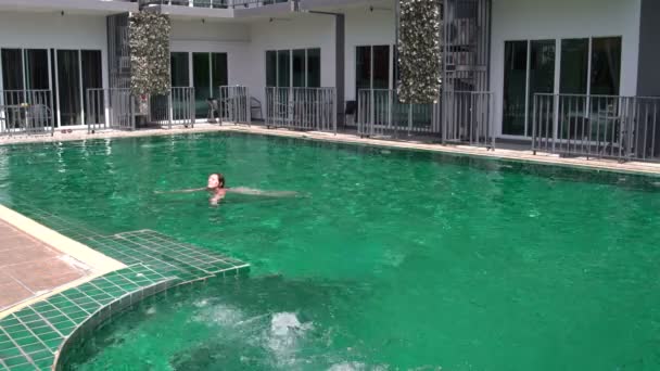 Mulher nada na piscina do hotel — Vídeo de Stock