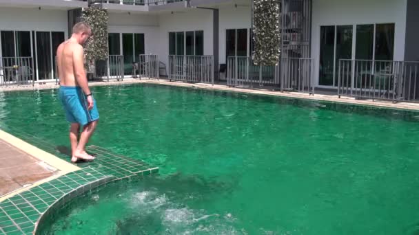 Un hombre entra en la piscina y nada — Vídeos de Stock