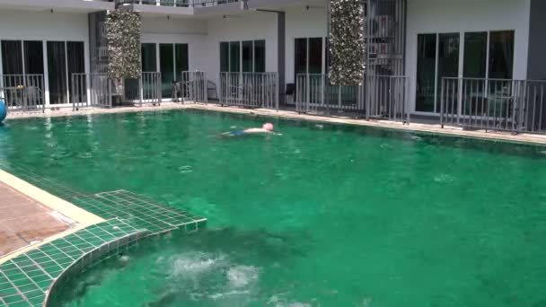 El hombre yace en la piscina — Vídeo de stock