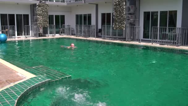 Homme nage dans la piscine extérieure 