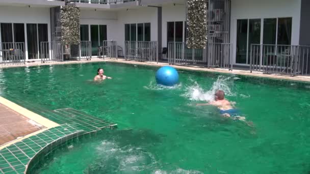 Uomo e donna giocano a palla in piscina — Video Stock