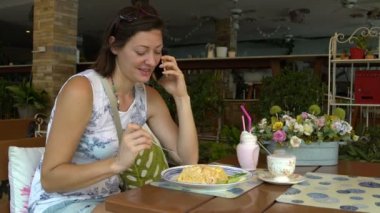 Kadın telefonda konuşurken ve khao phat yeme bir restoranda bir masada oturuyor