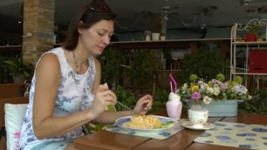 Bir kadın bir restoranda bir masada oturan ve khao phat yeme