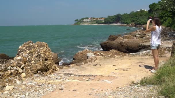 Eine Frau fotografiert ein Haus am Meer — Stockvideo