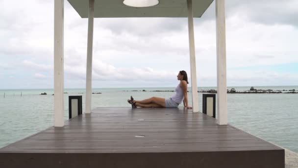 Mujer descansando en el muelle cerca del mar — Vídeo de stock