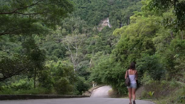 Uma mulher desce das montanhas na estrada — Vídeo de Stock