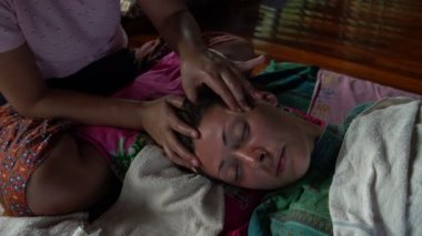 Tay baş masajı. Masöz temporal bölge ve kadının yüz masajları