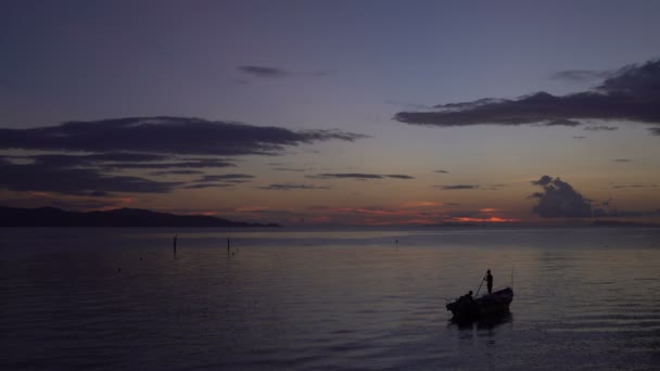 Silhouetted βάρκα στη θάλασσα στο ηλιοβασίλεμα — Αρχείο Βίντεο