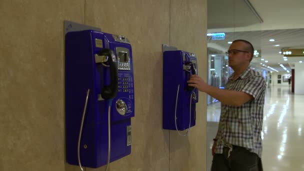 Een man komt naar de telefoon en oproepen — Stockvideo