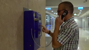 Adam telefon yaklaşımlar ve telefon cevaplar ve numarasını çevirir