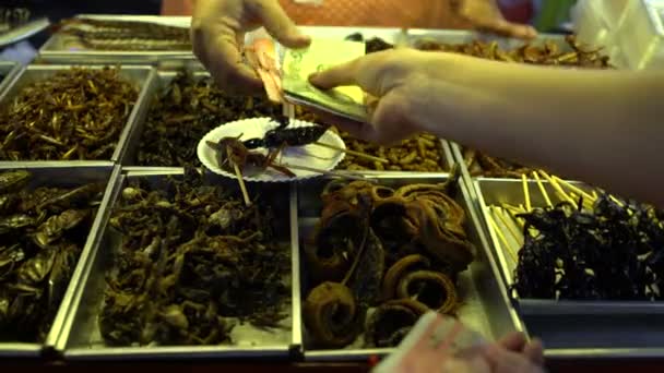 Thailändisches Street Food. Eine Frau kauft gebratene Insekten. — Stockvideo