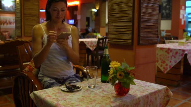 Una mujer sentada en un restaurante toma fotos de insectos fritos en un plato. Comida tailandesa . — Vídeos de Stock