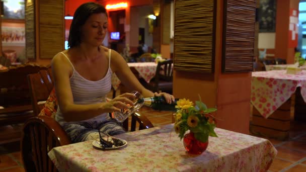 En kvinna i en restaurang häller öl i ett glas — Stockvideo