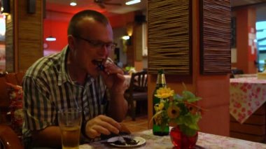 Kızarmış bir Akrep yeme ve bir Tayland restoranı bira içme bir adam