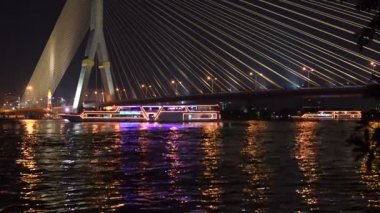 Işıkları ile eğlence tekneler nehrin kablo köprünün altında dağıtılmaktadır. Bölüm 1