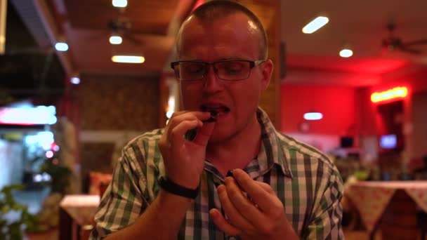 Un hombre comiendo un escorpión frito en un restaurante tailandés — Vídeo de stock