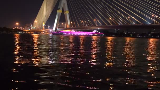 Na rzece pod most kabel jest łódka z oświetleniem — Wideo stockowe