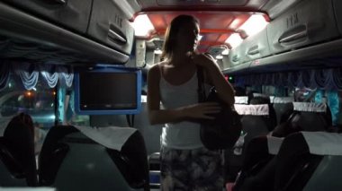 Kadın otobüs kabin içine geliyor ve sırt çantası Bagaj bölümünde koyar ve aşağı oturur