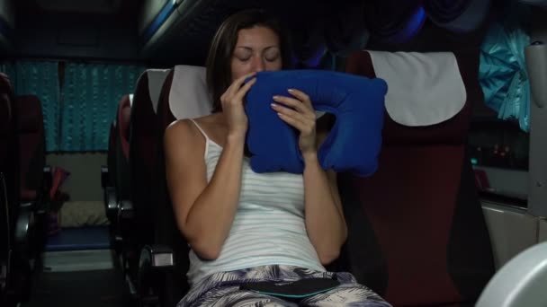 Μια γυναίκα που κάθεται στο λεωφορείο ύπνου φυσά ένα μαξιλάρι road, βάζει κάτω από το κεφάλι της, ρίχνει πίσω το κάθισμα — Αρχείο Βίντεο