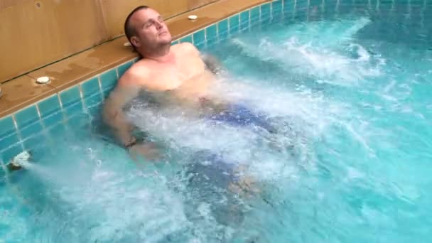 Ein Mann entspannt sich im Whirlpool — Stockvideo