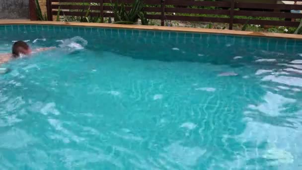 Mann schwimmt im Pool eines Hotels — Stockvideo