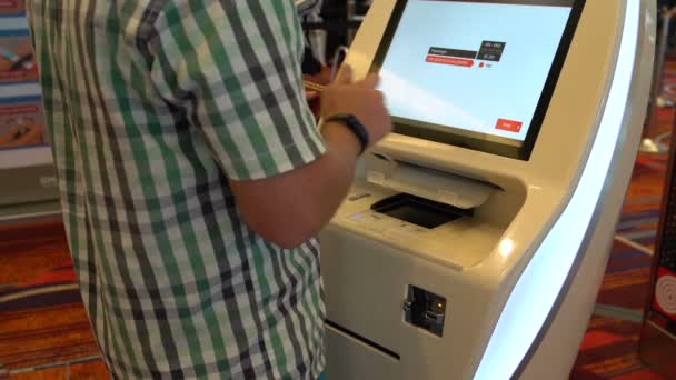 आदमी हवाई अड्डे टर्मिनल पर टिकट प्रिंट करता है — स्टॉक वीडियो