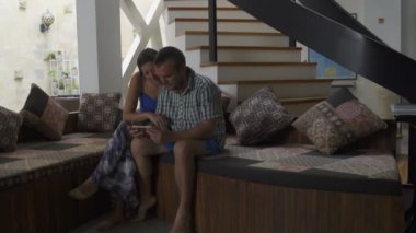 Evde koltukta oturan smartphone kullanan kadın adamla