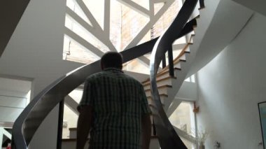 Bir adam evin en üst katında merdivenlerden tırmanıyor