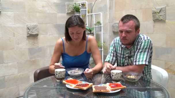 Ein Mann mit einer Frau isst Müsli und Toast mit Marmelade — Stockvideo