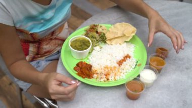 Sokak Hint yemeği Thali. Kadın sulama pirinç sosları
