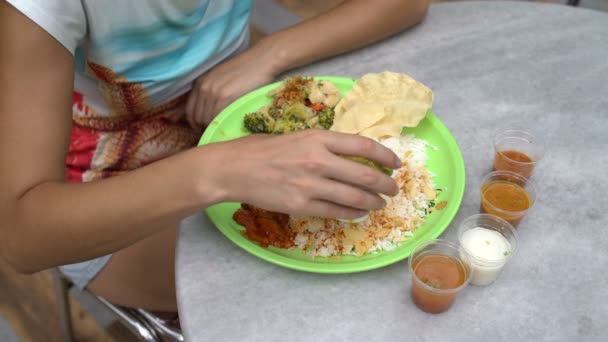 Street Indian food Thali. Mujer vierte arroz con salsa y come con sus manos — Vídeos de Stock