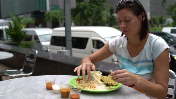 Une femme casse un gâteau indien traditionnel et mange du thali avec ses mains — Video