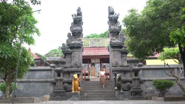 Una mujer con una falda larga desciende los escalones de un templo budista — Vídeo de stock