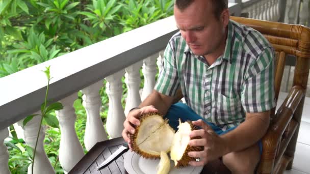 Een man reinigt durian met zijn handen — Stockvideo