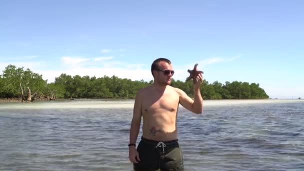 Man gooit Starfish in zee — Stockvideo