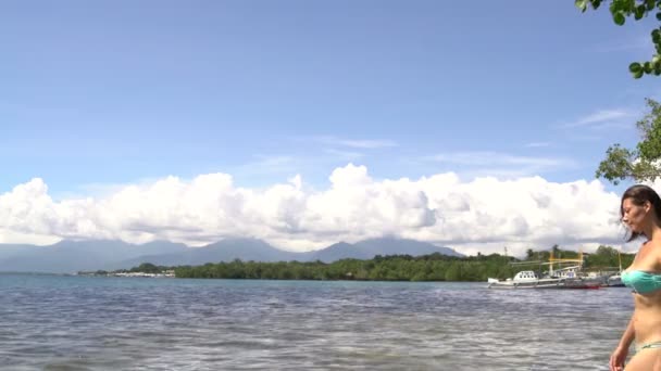 Eine Frau im Badeanzug geht am Strand entlang — Stockvideo