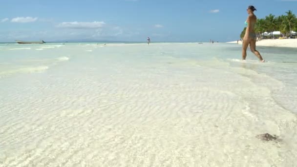 Una mujer camina hacia el mar y se sienta — Vídeos de Stock