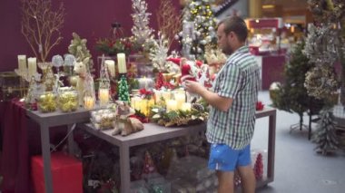 Bir adam Noel oyuncaklar alışveriş merkezinde seçer.