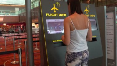 Bir kadın bir bilgileri terminal havaalanında kullanır.