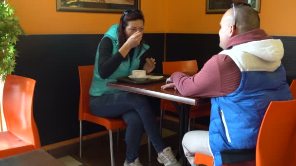 一男一女坐在桌旁的咖啡馆里聊天 吃汤与面包的妇女 — 图库视频影像