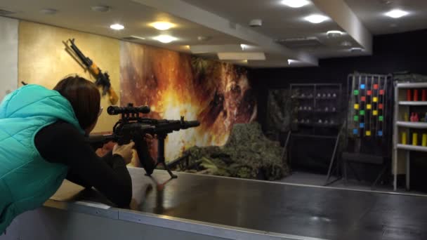 Schietbaan. Vrouw in glazen doelstellingen en scheuten van een Kalashnikov assault rifle op metalen doelen. — Stockvideo