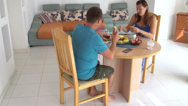 Mujer y hombre comen sentados a la mesa en casa — Vídeos de Stock