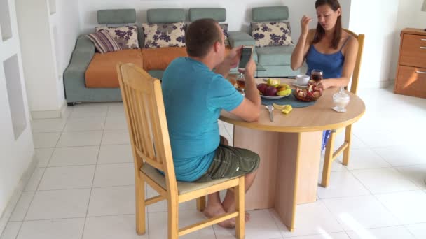 Man och hustru sitter vid bordet hemma och prata. — Stockvideo
